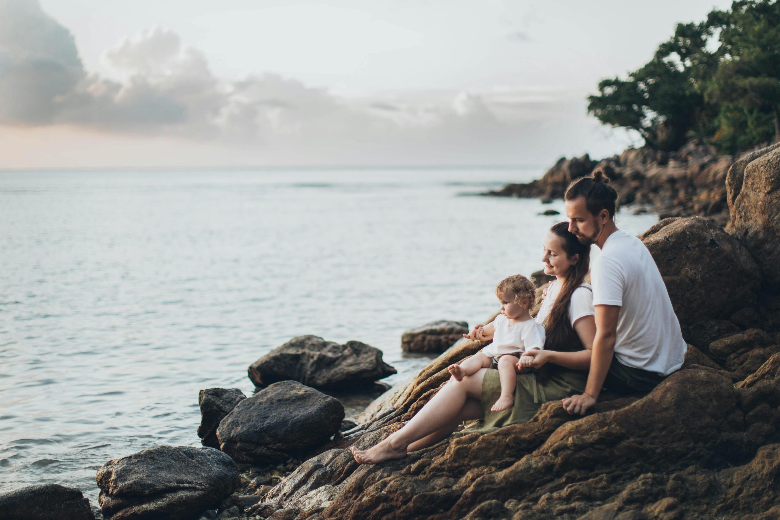 Family sat on rocks near the sea